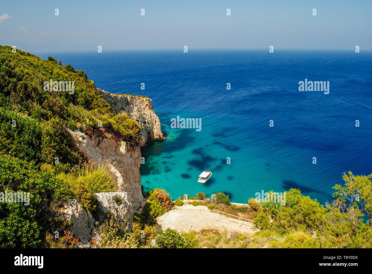 Un idilliaco litorale, con blue acque chiare e alta scogliera bordi Foto Stock