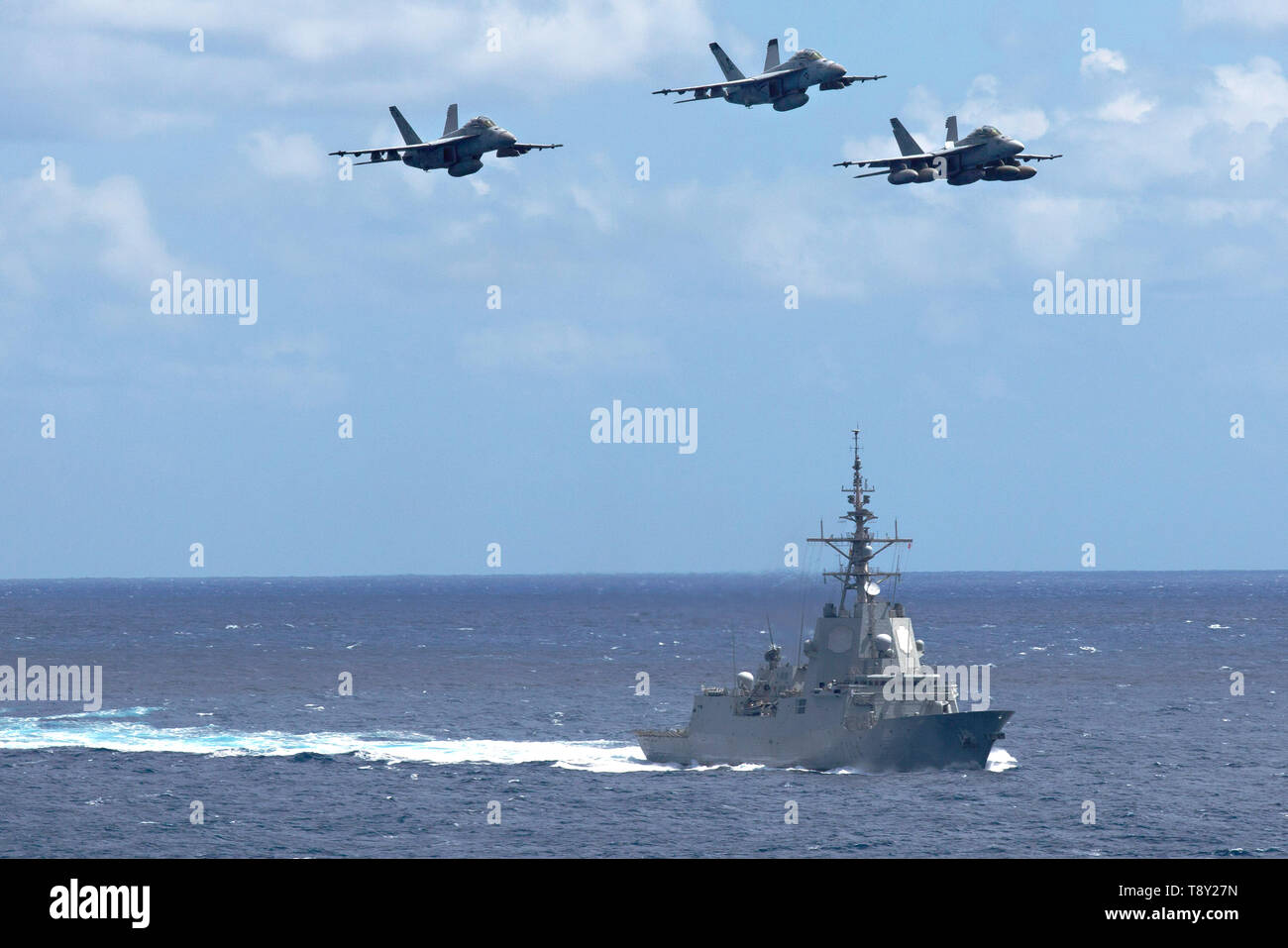 Tre Stati Uniti Navy F/A-18F Super Hornet fighter aircraft volare oltre la marina spagnola Alvaro de Bazan-class frigate ESP Mendez Nuñez durante le operazioni congiunte con la Nimitz-class portaerei USS Abraham Lincoln Carrier Strike gruppo Maggio 7, 2019 nel Mar Ionio. Foto Stock