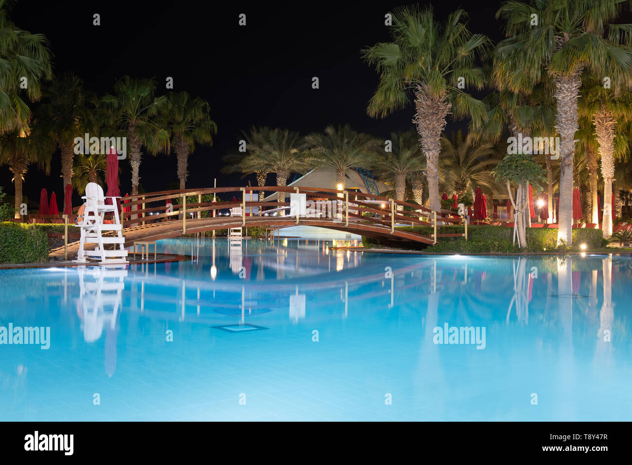 Piscina con ponte illuminato di notte Foto Stock