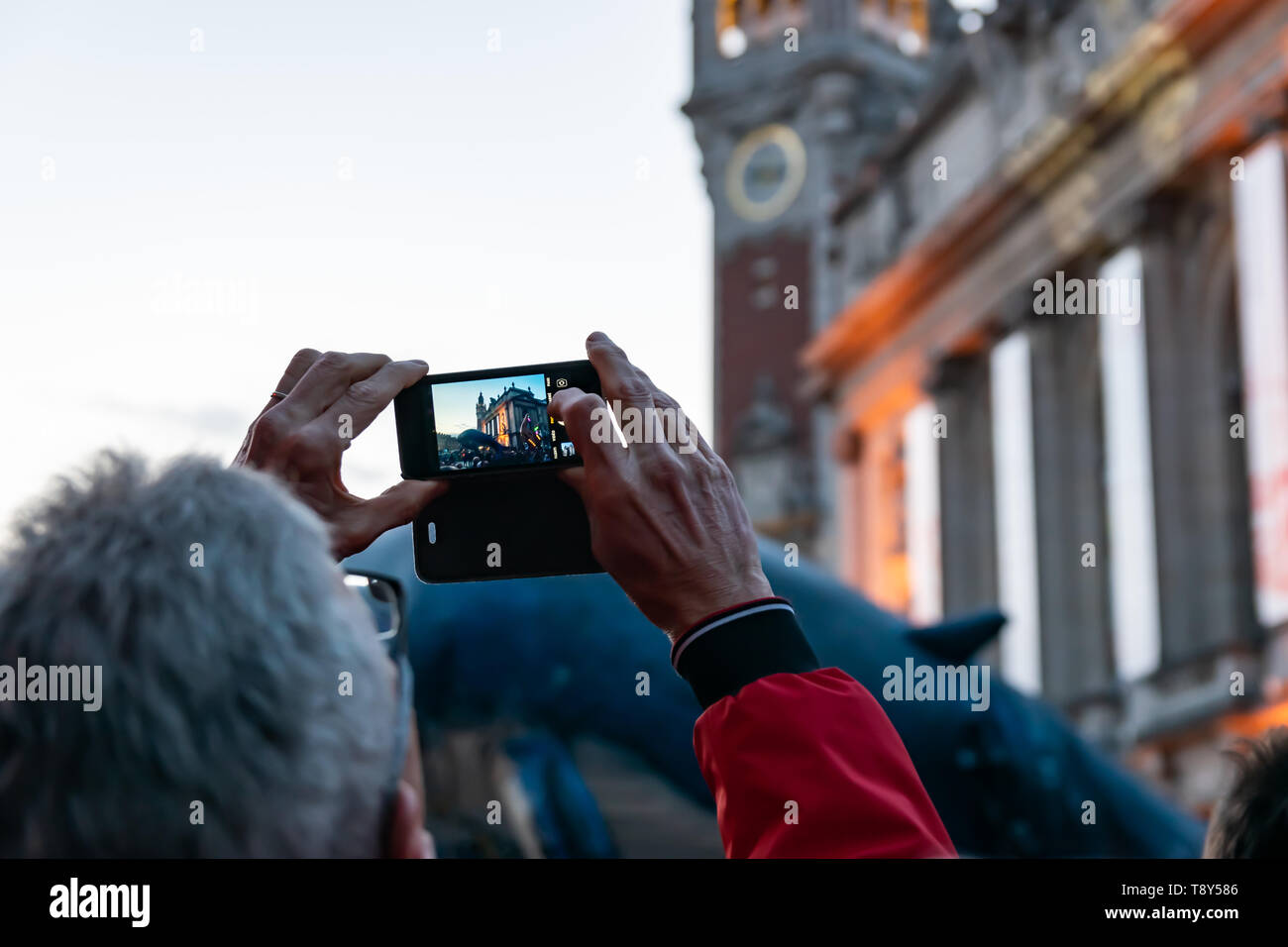 Lille, Francia-maggio 04,2019: uomo che fa video e foto con un telefono cellulare sulla grande sfilata di carnevale Eldorado Lille 3000. Foto Stock