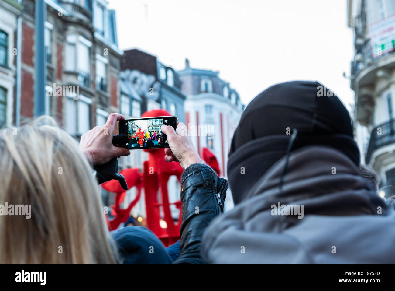 Lille, Francia-maggio 04,2019:donna fare video dal telefono cellulare sul grande sfilata di carnevale Eldorado Lille 3000. Foto Stock