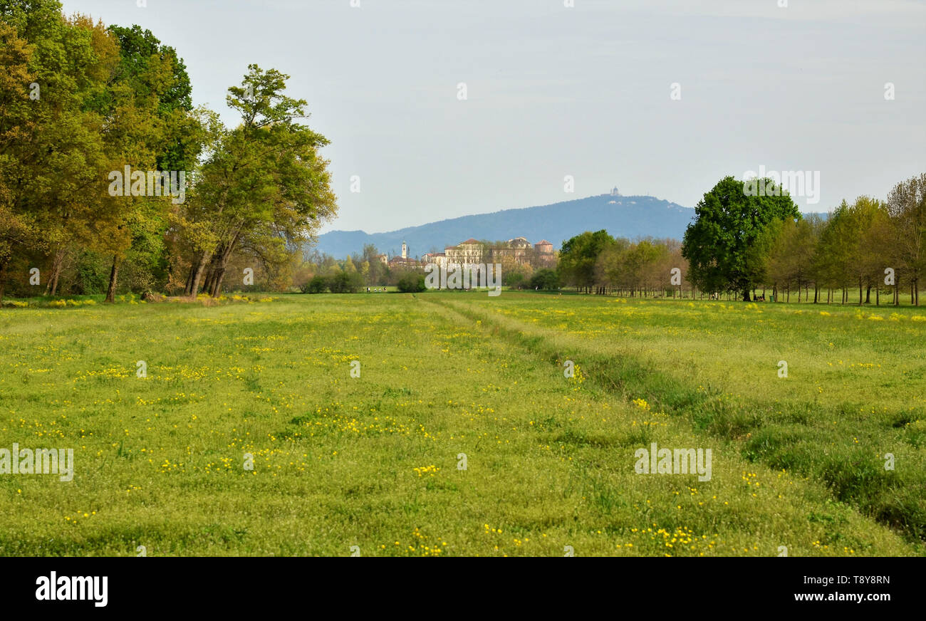 Venaria, Piemonte, Italia. Aprile 2019. Vista dal parco sullo sfondo la reggia di Venaria e sulle colline di Torino, la Basilica di Superga. Foto Stock