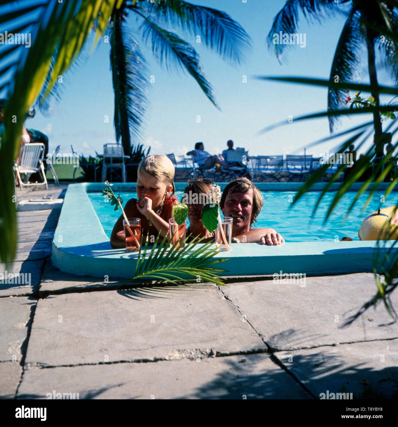 Prinz Leopold von Bayern und seine Ehefrau Ursula und ein gemeinsames tipo entspannen gemeinsam in einem Schwimmbecken während eines Urlaubs auf den Bahamas, ca. 1980er Jahre. Il principe Leopoldo di Baviera e di sua moglie Ursula e un bambino insieme rilassatevi in piscina durante una vacanza alle Bahamas, circa ottanta. Foto Stock