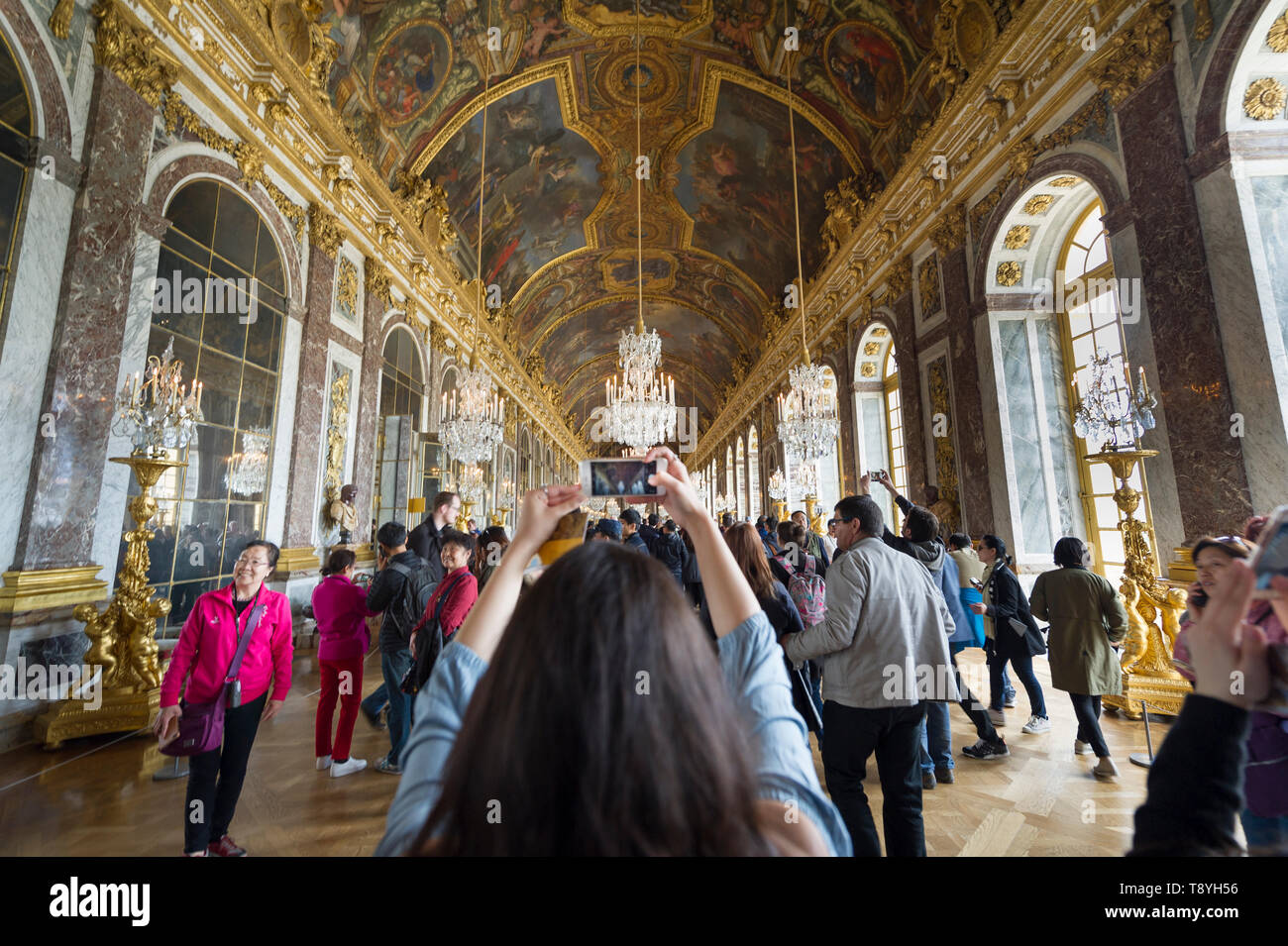 Turistica prendendo le foto presso la Sala degli Specchi nel palazzo di Versailles Foto Stock
