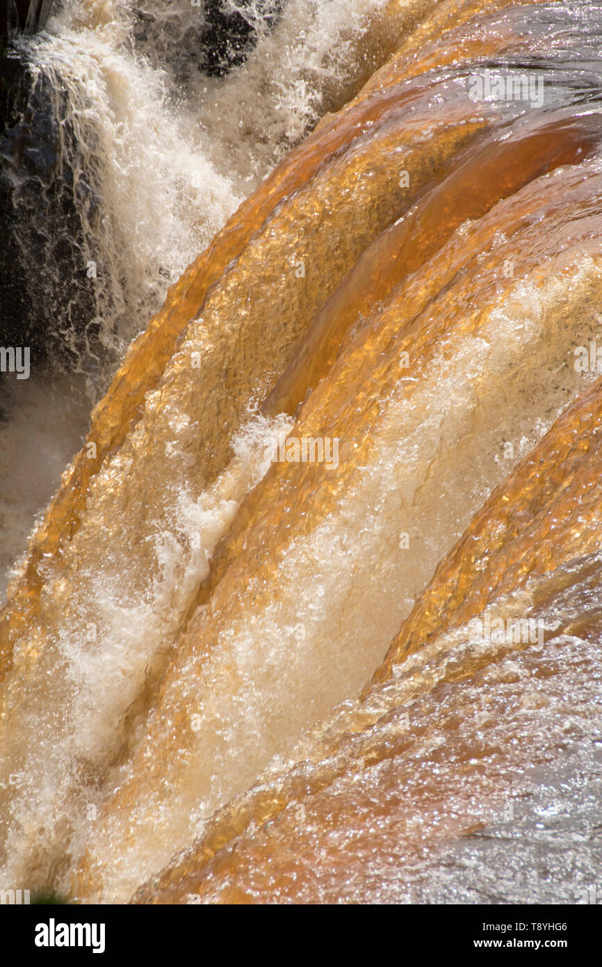 Cascate di acqua su Kakabeka Falls, Ontario. Il colore dell'acqua se a causa di tannino presente nell'acqua di vegetazione. Foto Stock