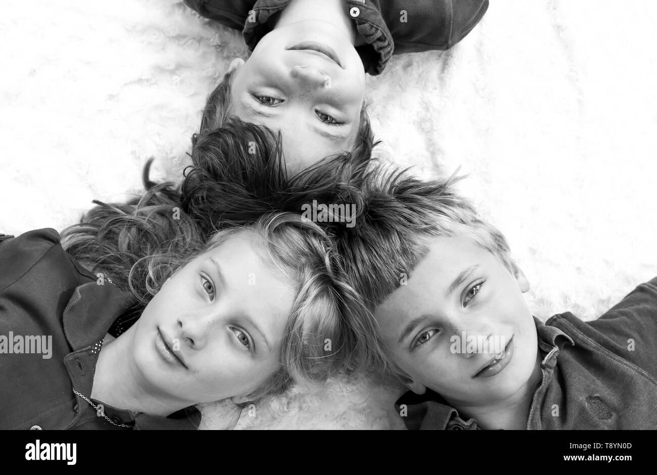 Ritratto in bianco e nero di tre giovani fratelli visto da sopra Foto Stock