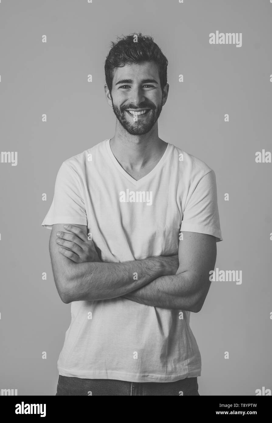 Ritratto di giovane uomo attraente con la barba occhi blu e uno splendido sorriso. Millenario modello hipster fiduciosi in posa e modellizzazione contro neut Foto Stock