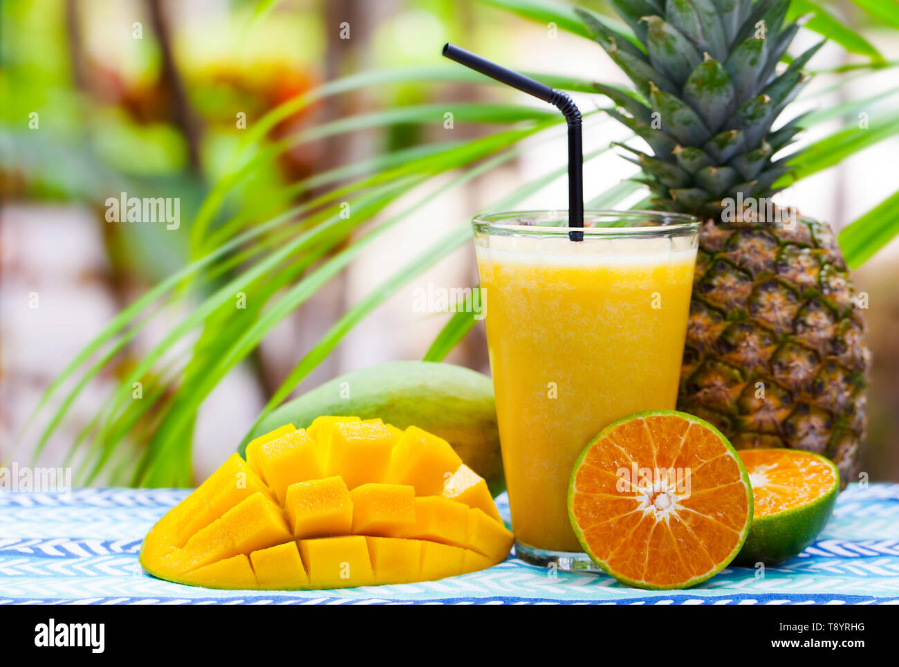 Frutta fresca tropicale succo, smoothie in vetro su estate sfondo all'aperto. Copia dello spazio. Foto Stock