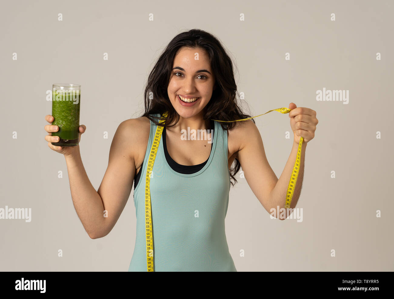 Centro fitness donna sorridente felice con piano di dieta per perdere peso; esercizio e verde frullato vegetale bibita salutare. In bellezza la cura del corpo, Health Fitness D Foto Stock