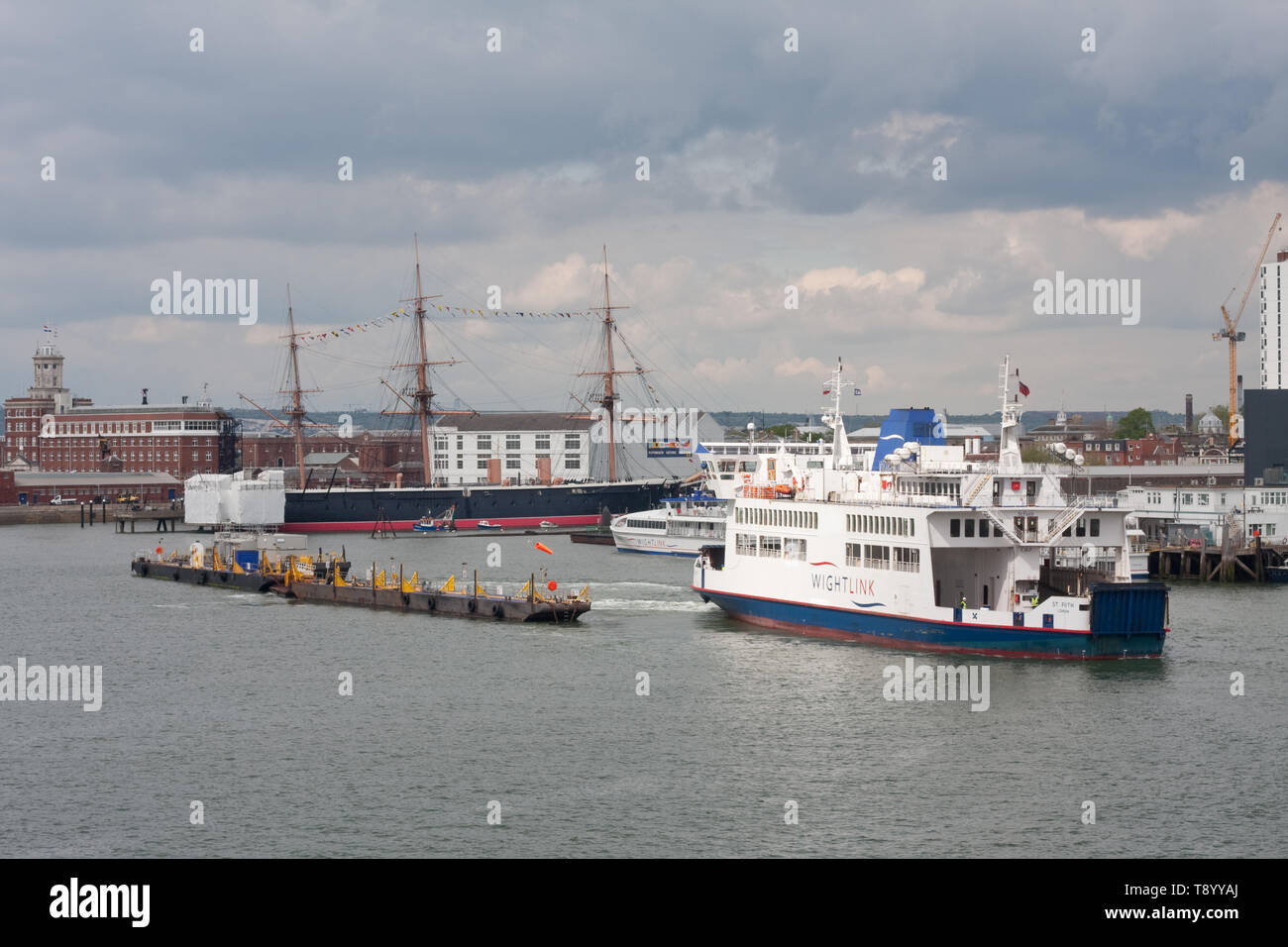 Un traghetto Wightlink lascia Portsmouth dock wth HMS Warrior 1860 in background Foto Stock