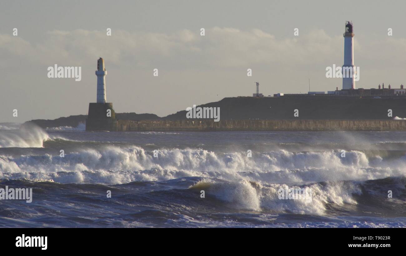 Faro Girdleness e ruvide di onde che si infrangono sulla spiaggia di Aberdeen durante una tempesta di neve. La Scozia, Regno Unito. Foto Stock