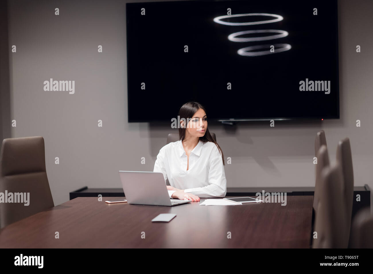 Bella giovane imprenditrice utilizzando laptop in sala conferenze Foto Stock