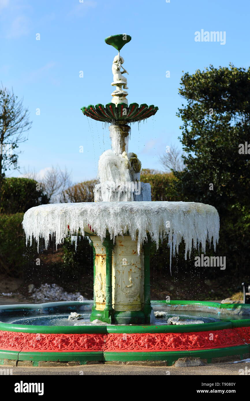Grado 2 elencati in ferro battuto fontana nel lungomare giardini di st annes on sea. L'acqua ha congelato ghiaccioli lasciando gocciolare nel sole mattutino Foto Stock