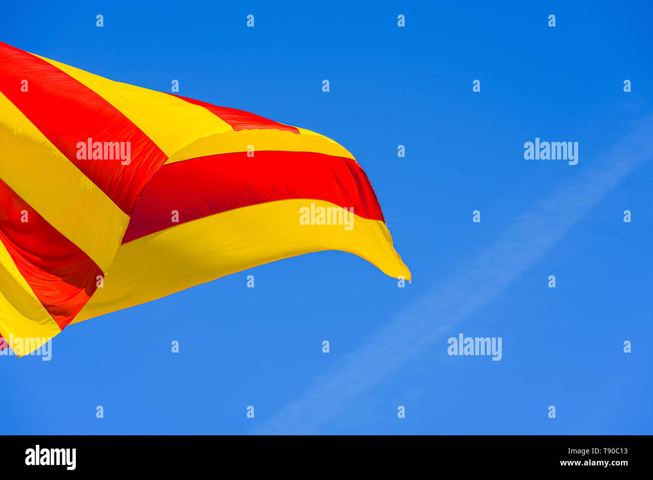 Bandiera della Catalogna e Valencia che ondeggia con il suo rosso e strisce gialle nel vento. Foto Stock