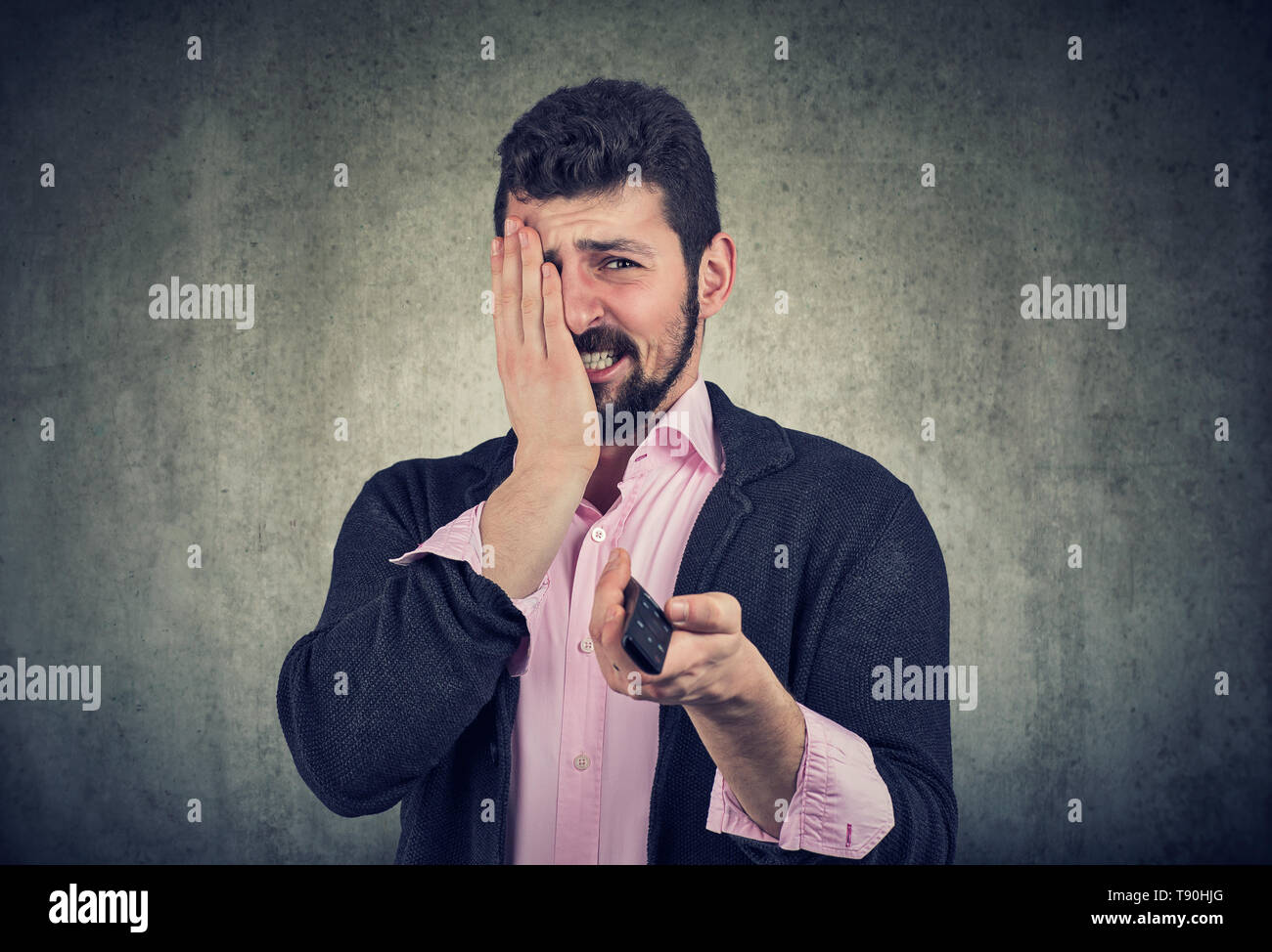 Ansiosi spaventata giovane uomo a guardare i film horror o news Foto Stock