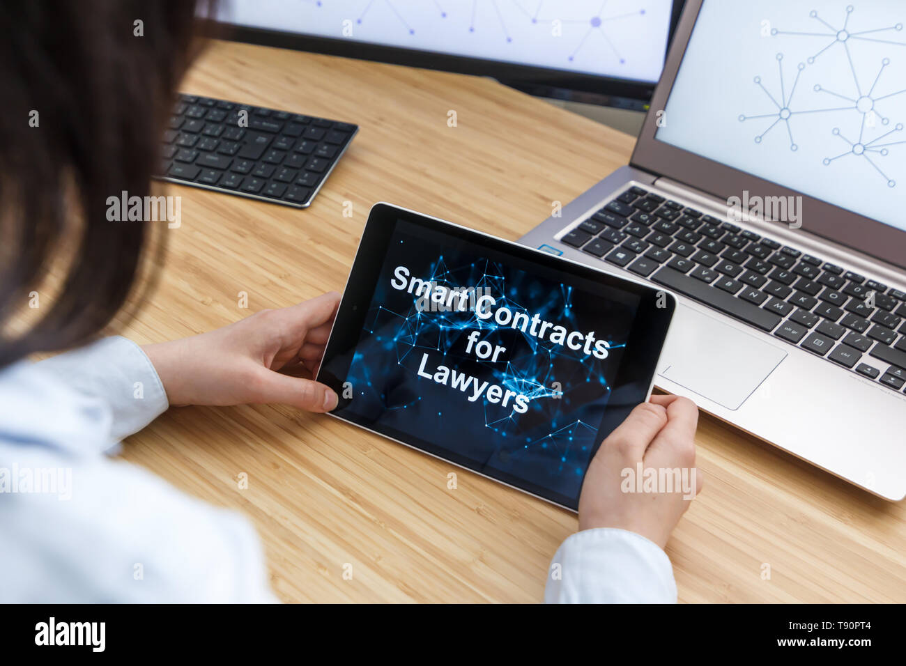 Femmina di business utilizzando Smart contratti per gli avvocati. Illustrazione di Ethereum Blockchain sullo schermo del Tablet PC e laptop. Foto Stock