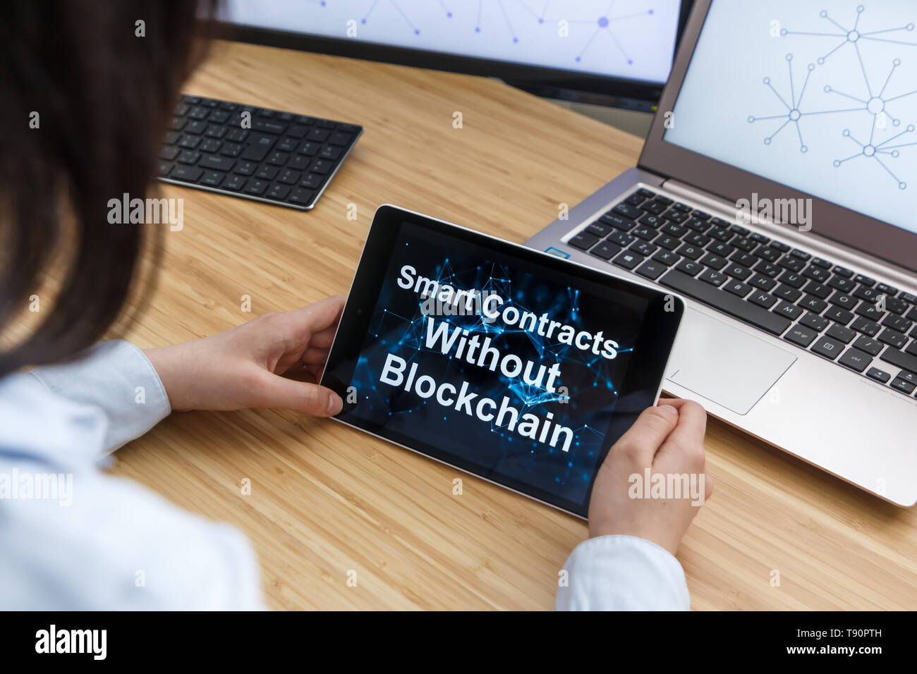 Femmina di business utilizzando Smart contratti senza Blockchain. Illustrazione di Ethereum Blockchain sullo schermo del Tablet PC e laptop. Foto Stock