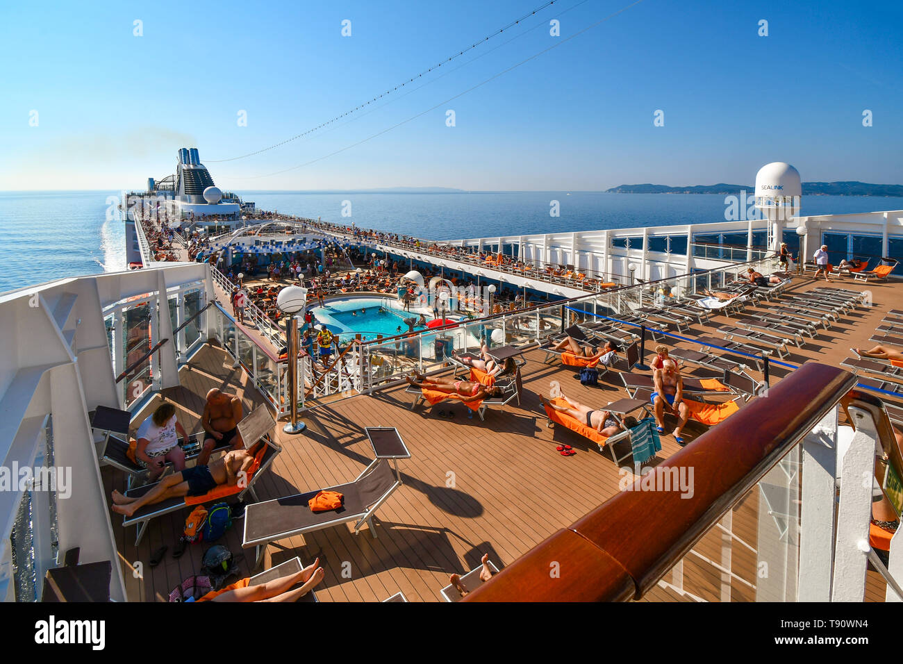 Una grande nave da crociera con i turisti sul ponte si avvicina all'isola di Corfu Grecia in un giorno di estate nel Mar Ionio. Foto Stock