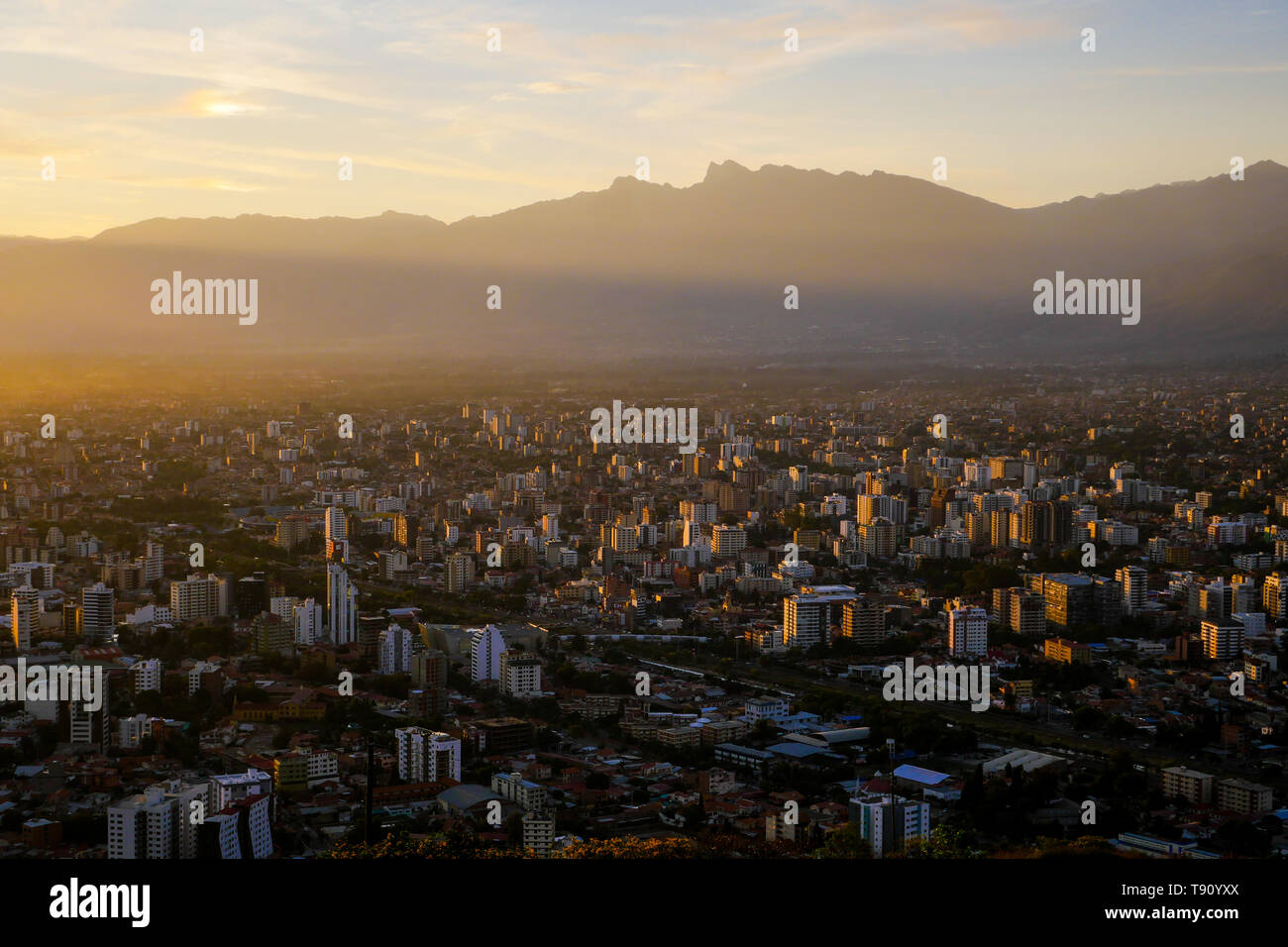 Vista al tramonto di Cochabamba dalla cima della collina con Tunari di montagna come sfondo Foto Stock