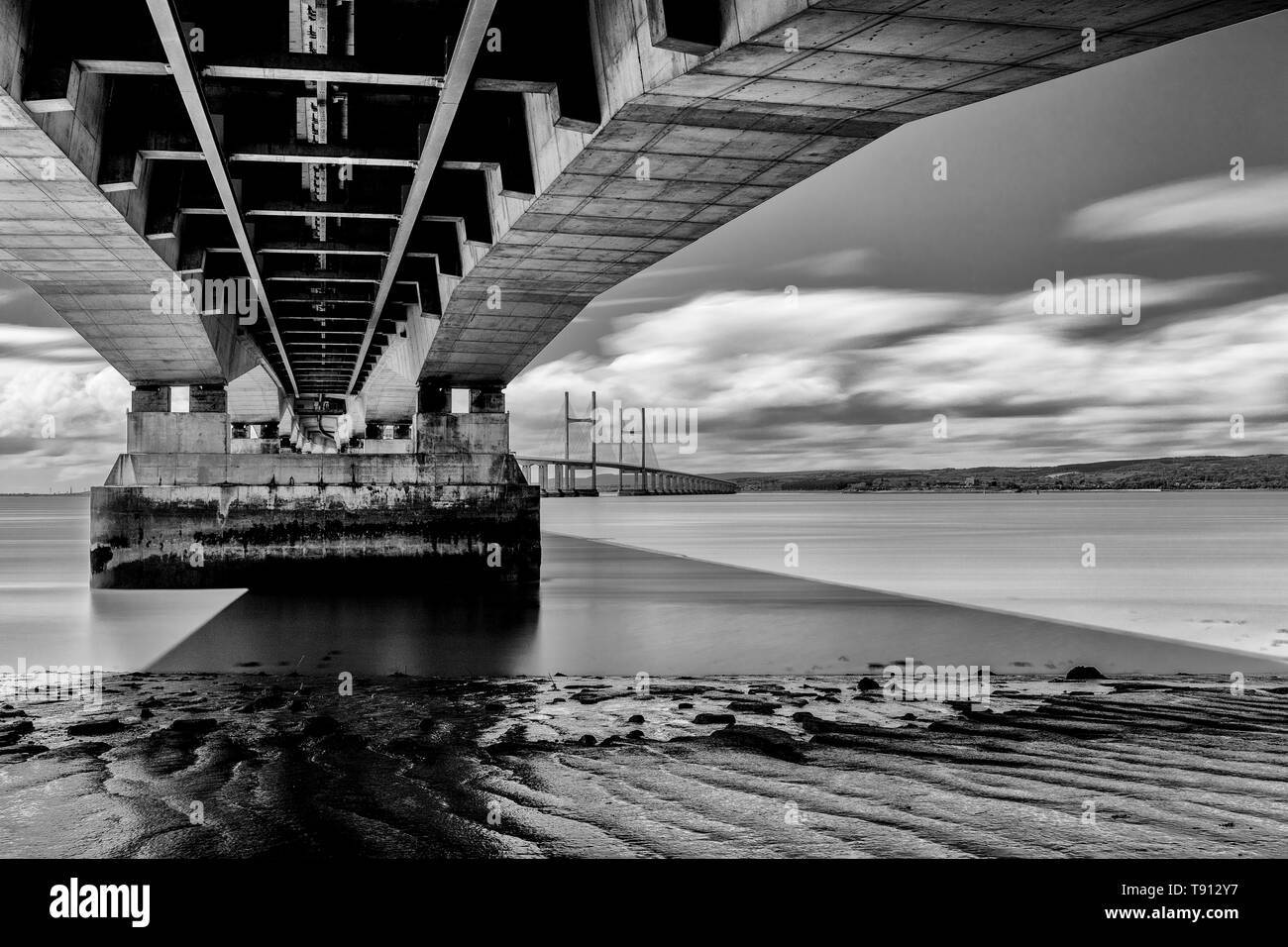 Il Principe di Galles Bridge, seconda Severn attraversando il Canale di Bristol, una lunga esposizione immagine con acqua liscia e striature sulle nuvole Foto Stock