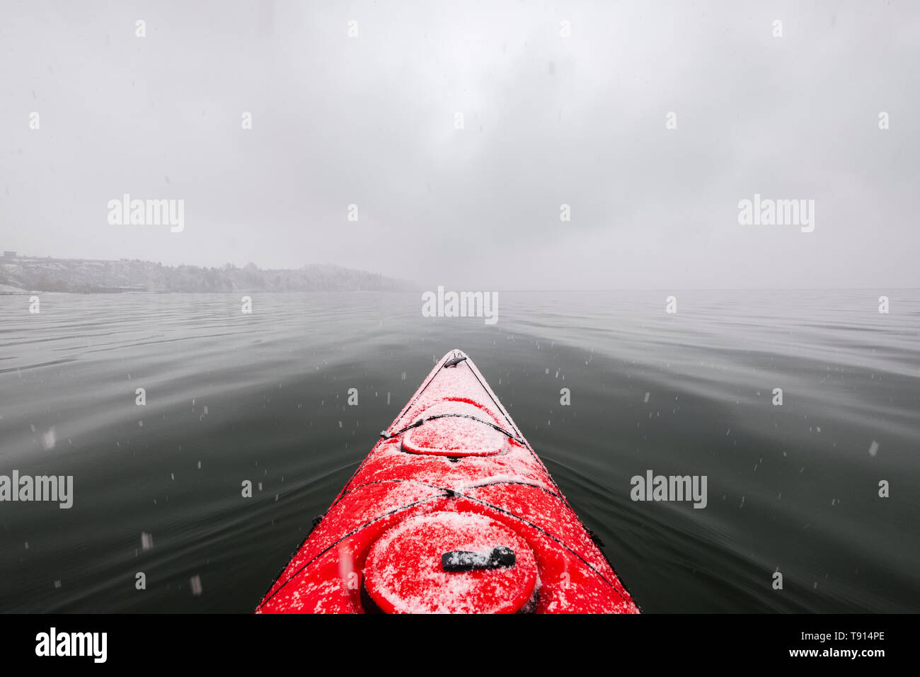 Red kayak sul lago Okanagan in Penticton, British Columbia, Canada durante un inverno tempesta di neve Foto Stock