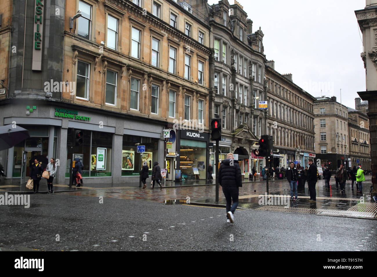 Glasgow Scotland Street scene di persone su strada di attraversamento sotto la pioggia Foto Stock