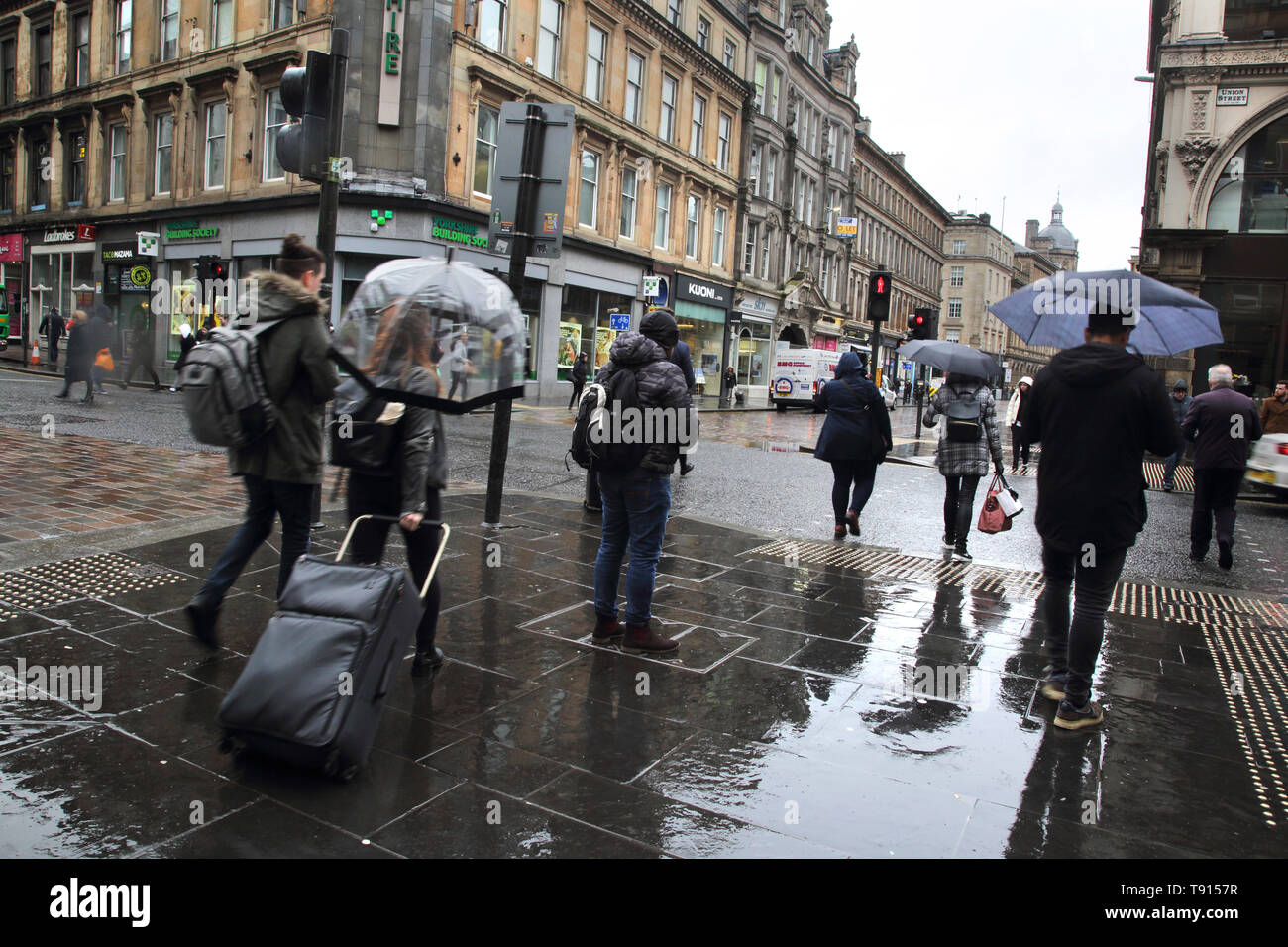 Glasgow Scozia centro città di persone in attesa di attraversare la strada al semaforo sotto la pioggia Foto Stock