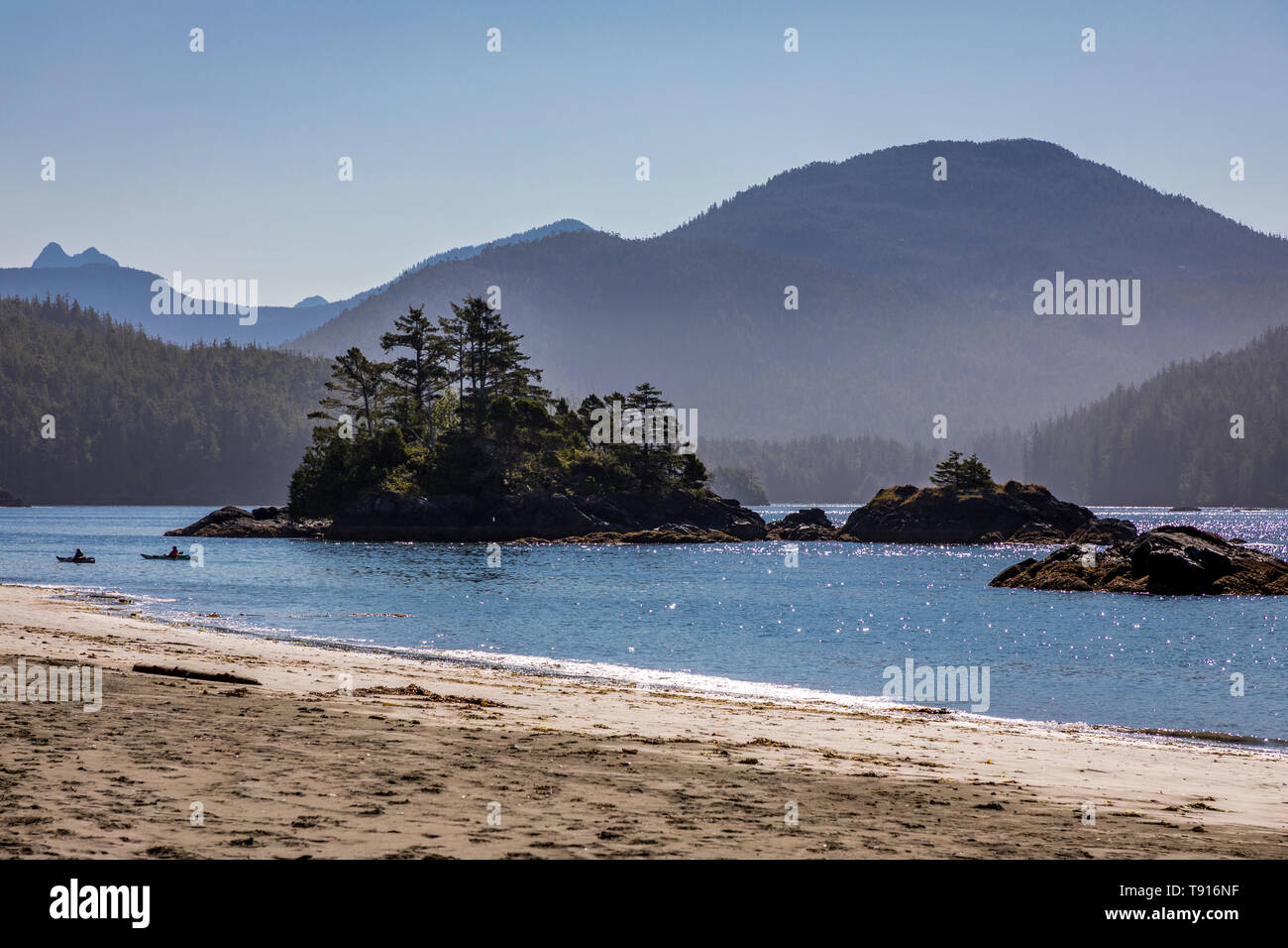 Due kayakers paddle passano un isolotto a Benson punto sulla isola di Nootka, Nuchatlitz Parco Provinciale, British Columbia, Canada. Foto Stock