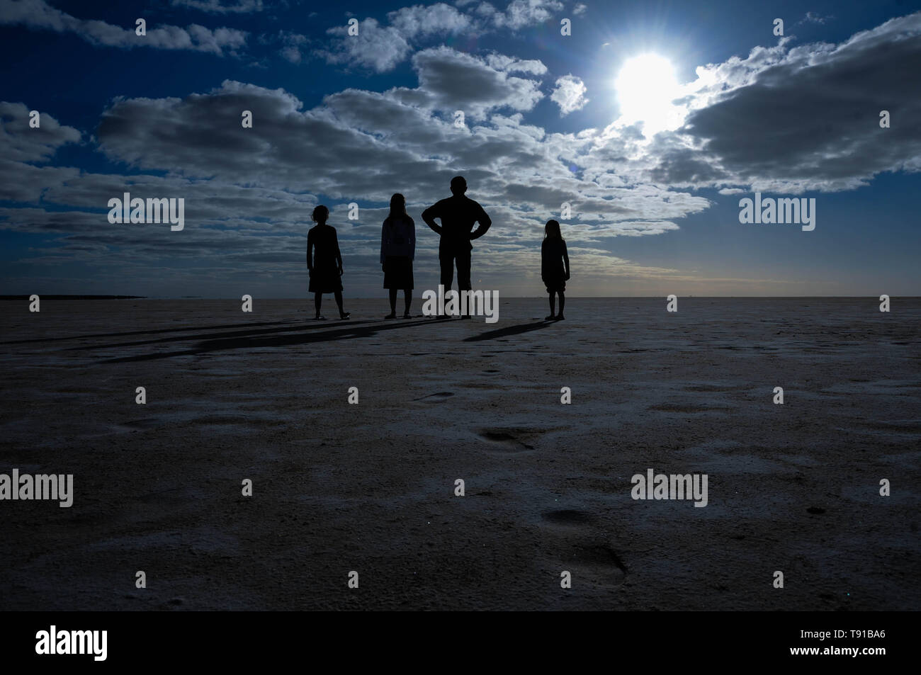 Un padre e i suoi figli pongono sul letto asciutto del fiume nel lago Eyre in Australia Foto Stock