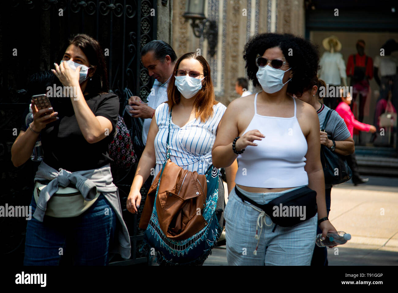 Mexiko Stadt, Messico. 15 Maggio, 2019. Le donne a piedi nel centro della città con maschere viso a causa di un elevato inquinamento atmosferico. A causa della maggiore particolato livelli, la commissione ambientale dell'area metropolitana intorno alla capitale messicana ha invitato la popolazione a limitare l'uso di auto, ad astenersi da attività sportive all'aperto e a tenere le porte e le finestre chiuse. Credito: Jair Cabrera Torres/dpa/Alamy Live News Foto Stock