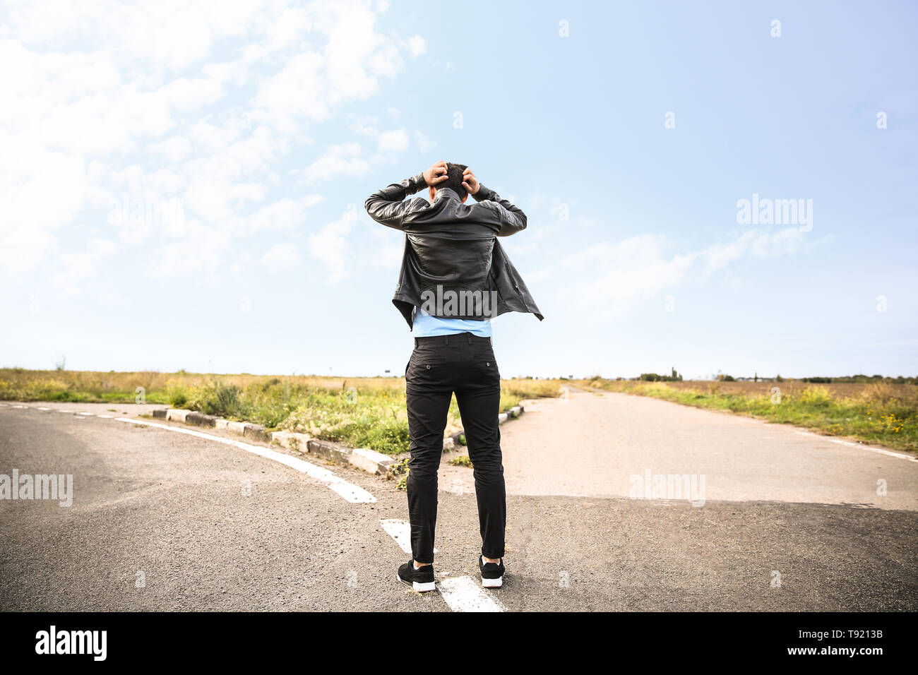 Ha sottolineato l'uomo in piedi al bivio. Concetto di scelta Foto Stock