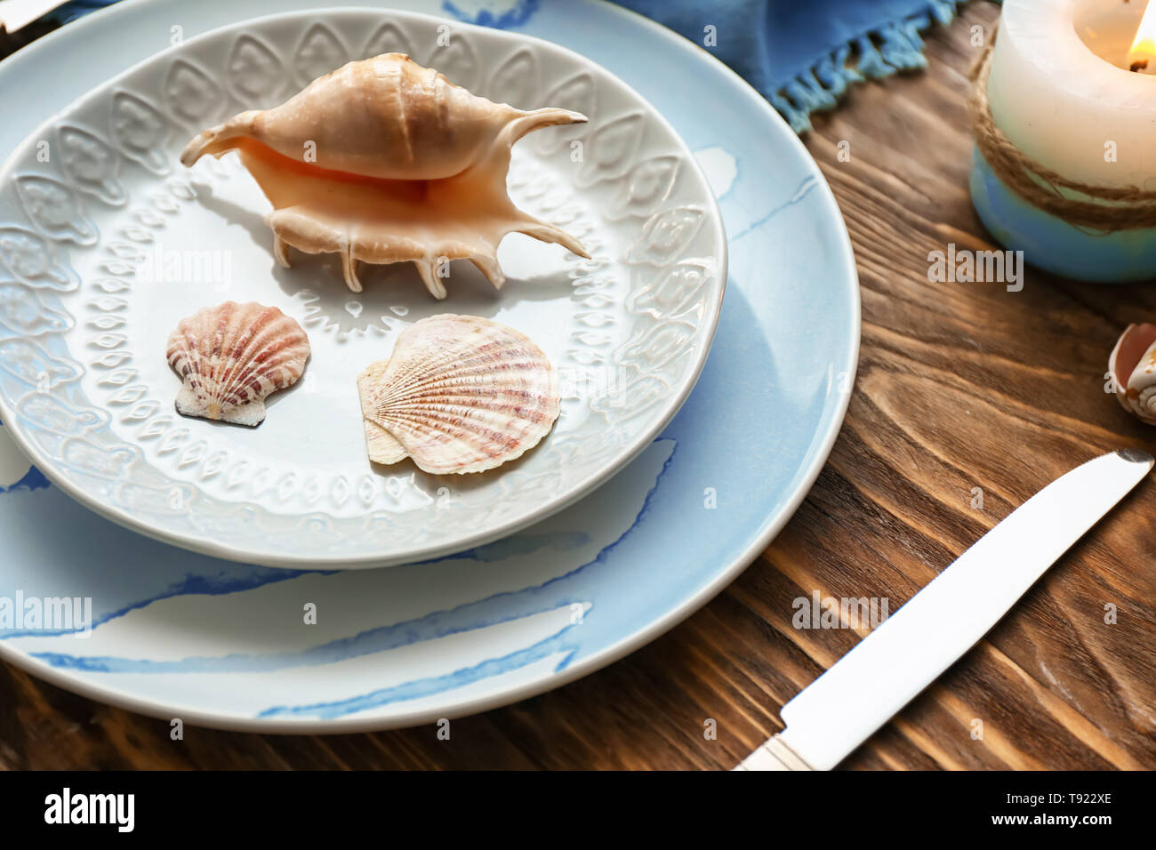 Bella tabella impostazione con conchiglie di mare su sfondo di legno Foto Stock