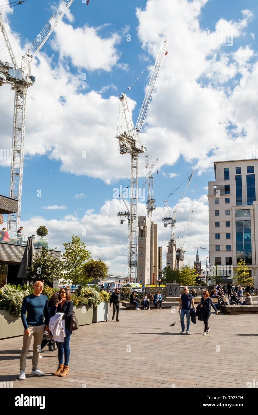 Gli acquirenti e i turisti presso il recentemente aperto del carbone scende cantiere, King's Cross, Londra, Regno Unito, 2019, la riqualificazione continua in background Foto Stock