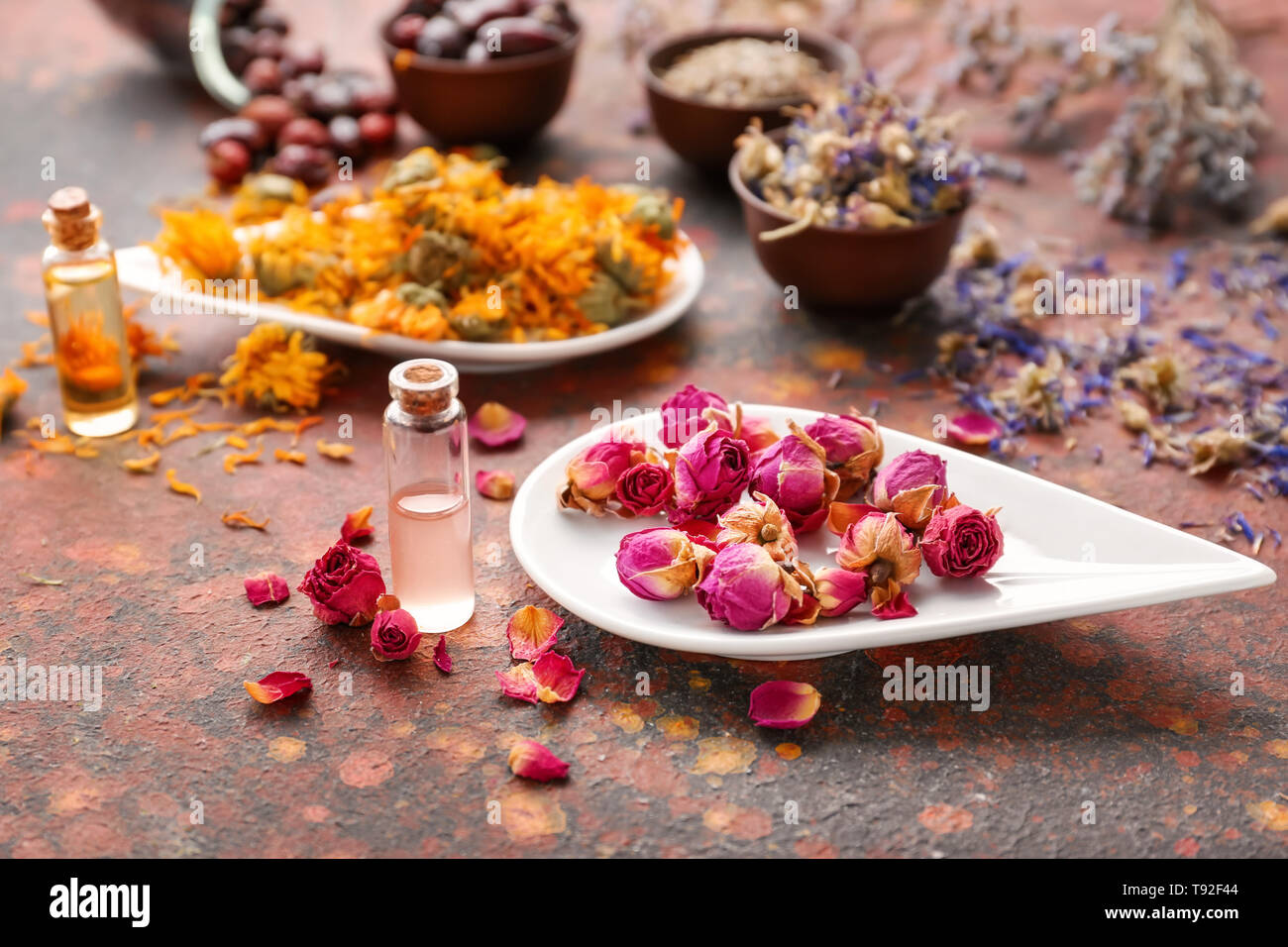 Aromatico fiori secchi con olio essenziale sulla tabella dei colori Foto Stock