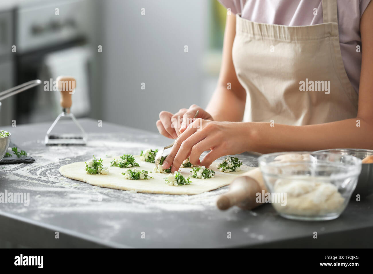 Donna fare gustosi ravioli di verdure su tavola Foto Stock