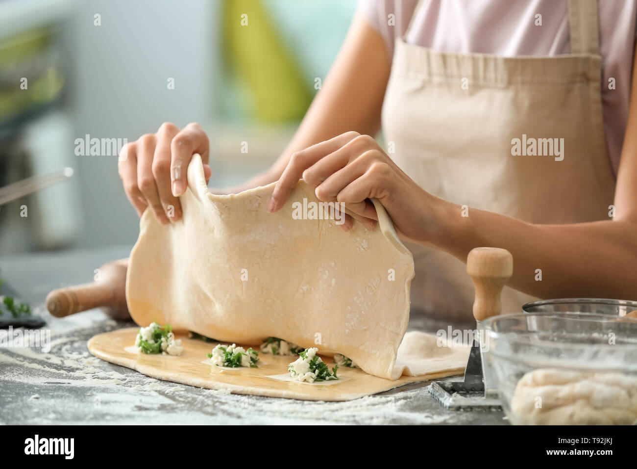 Donna fare gustosi ravioli di verdure su tavola Foto Stock