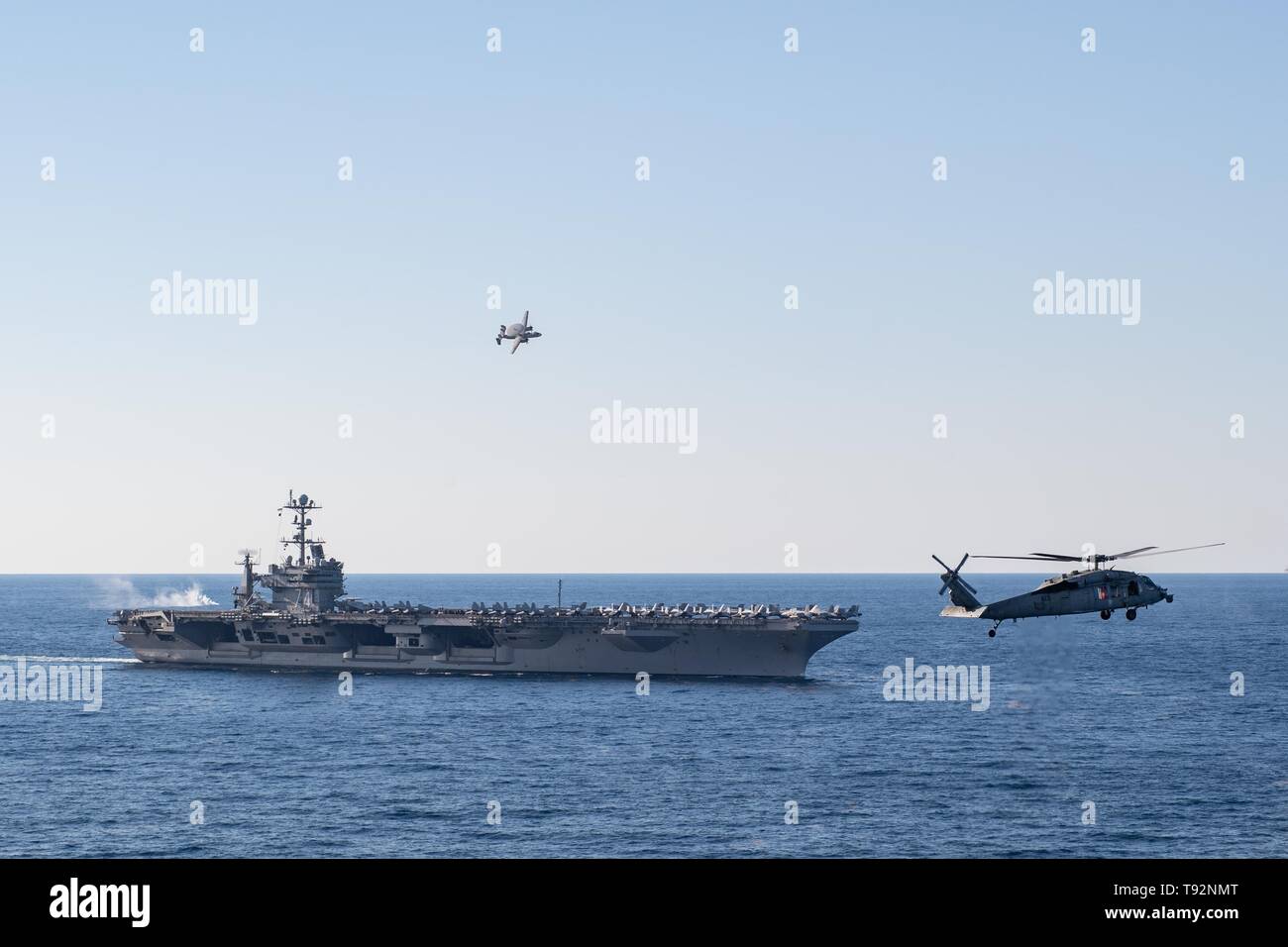 Un E-2C Hawkeye, assegnati al vettore Airborne Early Warning Squadron (VAW) 117, vola sopra la portaerei USS John C. Stennis (CVN 74) come un MH-60S Sea Hawk, diritto, assegnato al mare in elicottero Combat Squadron (HSC) 14, vola al fianco di John C. Stennis durante un'aria di dimostrazione di potenza nell'Oceano Atlantico, 14 maggio 2019. John C. Stennis ha oltre 1000 membri della famiglia e amici ha intrapreso una crociera tiger a seguito di una distribuzione per gli Stati Uniti 3a, 5a, 6a, e 7a flotta aree di responsabilità. John C. Stennis è operante negli Stati Uniti 2a flotta a sostegno di operazioni navali di ami Foto Stock