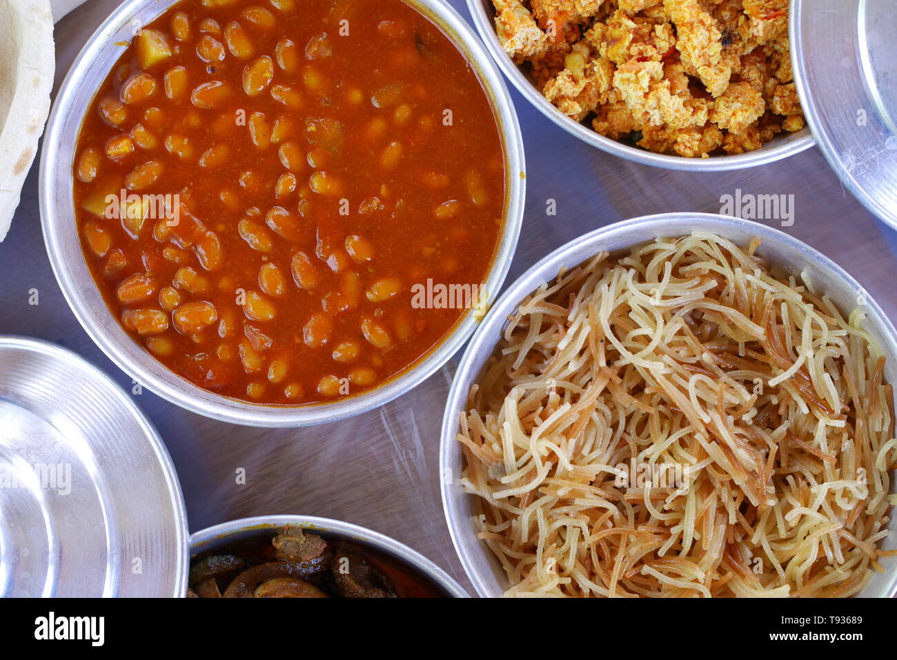 Bahrain colazione a base di fagioli, balaleet, vermicelli, uova strapazzate, pomodori, frittura di fegato, in ciotole di metallo Foto Stock