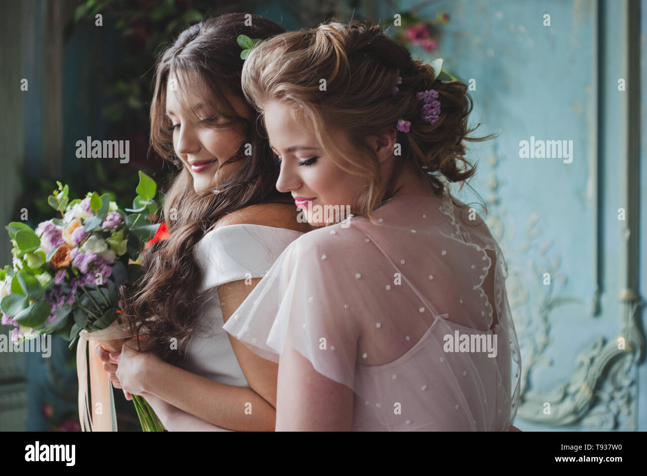 Sposa e le sue damigelle hanno. Bella giovane donna in abiti e con bouquet di fiori freschi. Foto Stock