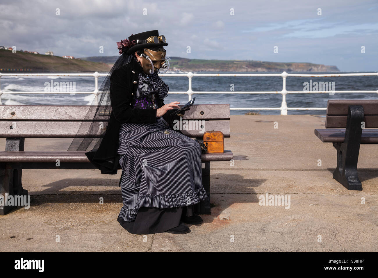 Un Goth / Steampunk donna controlla il suo telefono durante una pausa nel Weekend di Goth celebrazioni a Whitby,North Yorkshire, Inghilterra, Regno Unito Foto Stock