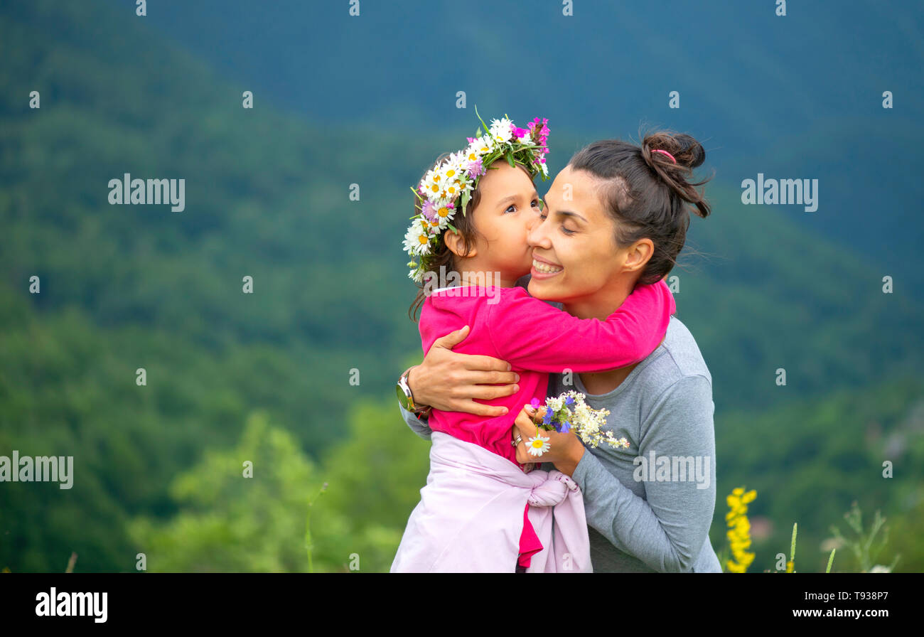 Sorridente madre e figlia piccola sulla natura. Festa della mamma Foto Stock