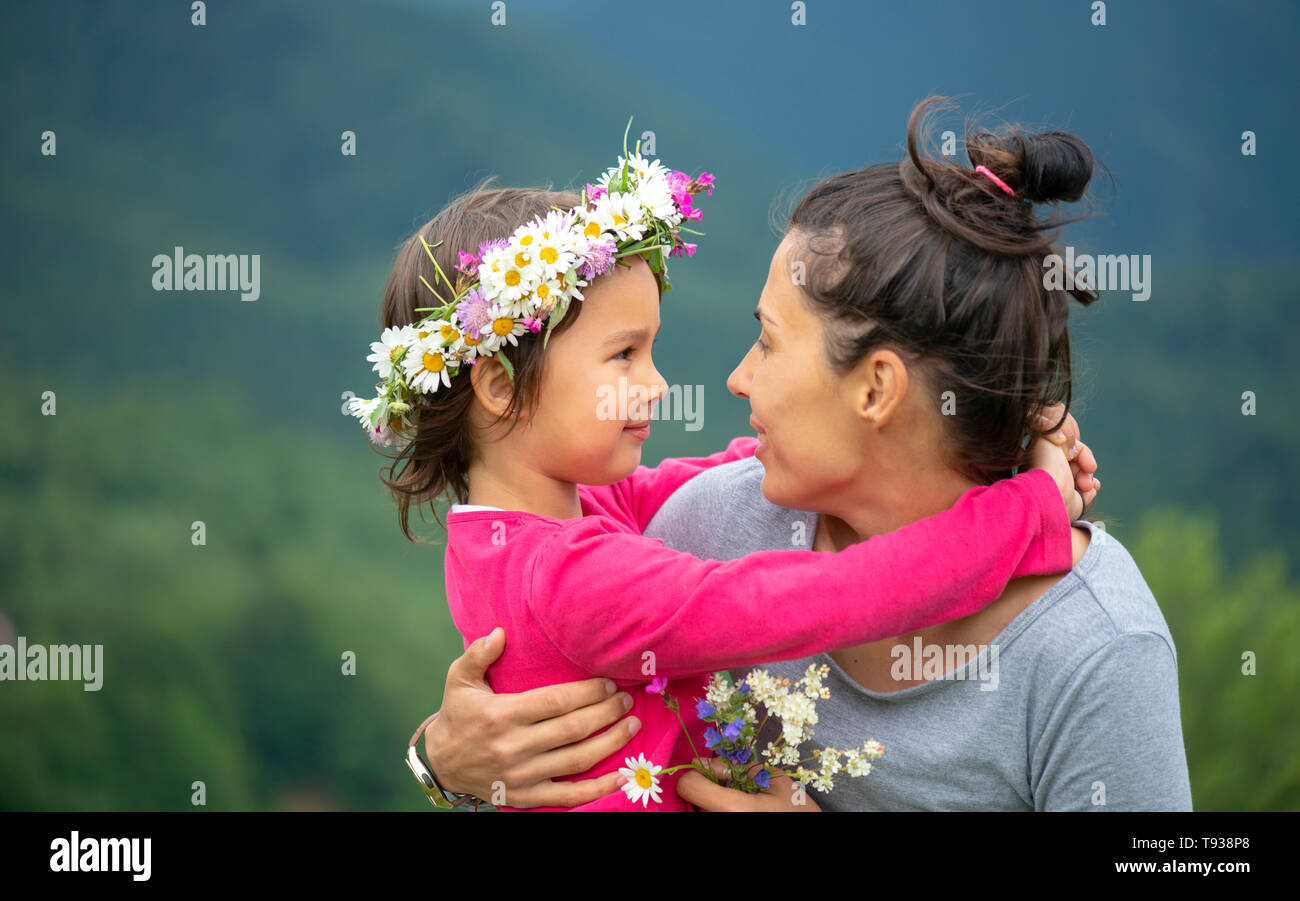 Sorridente madre e figlia piccola sulla natura. Festa della mamma Foto Stock