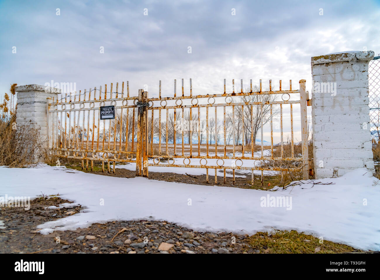 La proprietà privata con un nessun segno sconfinamenti sul cancello arrugginito visto in inverno Foto Stock