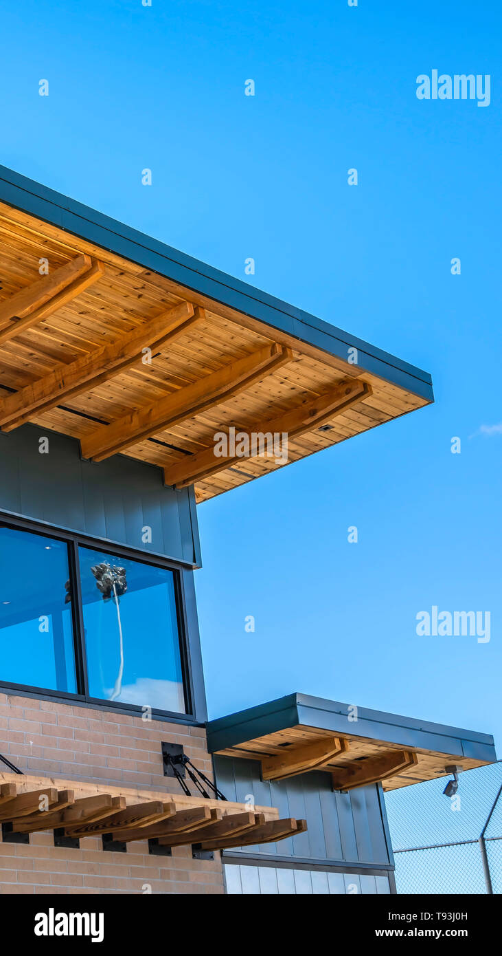 Cancellare esterna verticale di un edificio in mattoni con tetto piatto e grandi finestre di vetro Foto Stock
