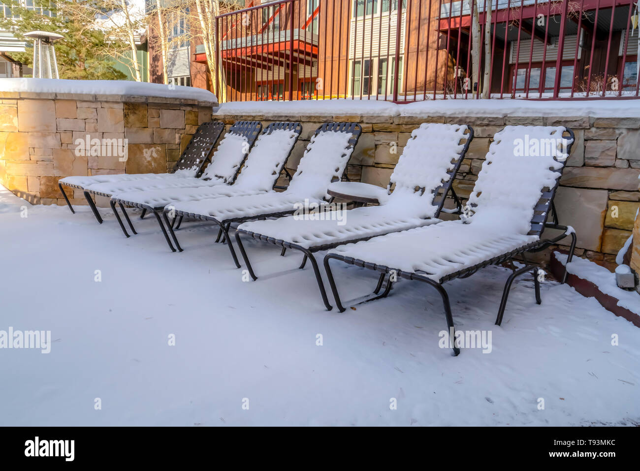Outdoor chaise longue sedie e tavolo contro un edificio su una soleggiata giornata invernale Foto Stock