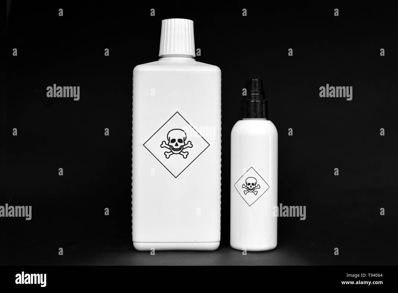 Due bottiglie di bianco con veleno cartelli di avvertimento su di loro su sfondo nero Foto Stock