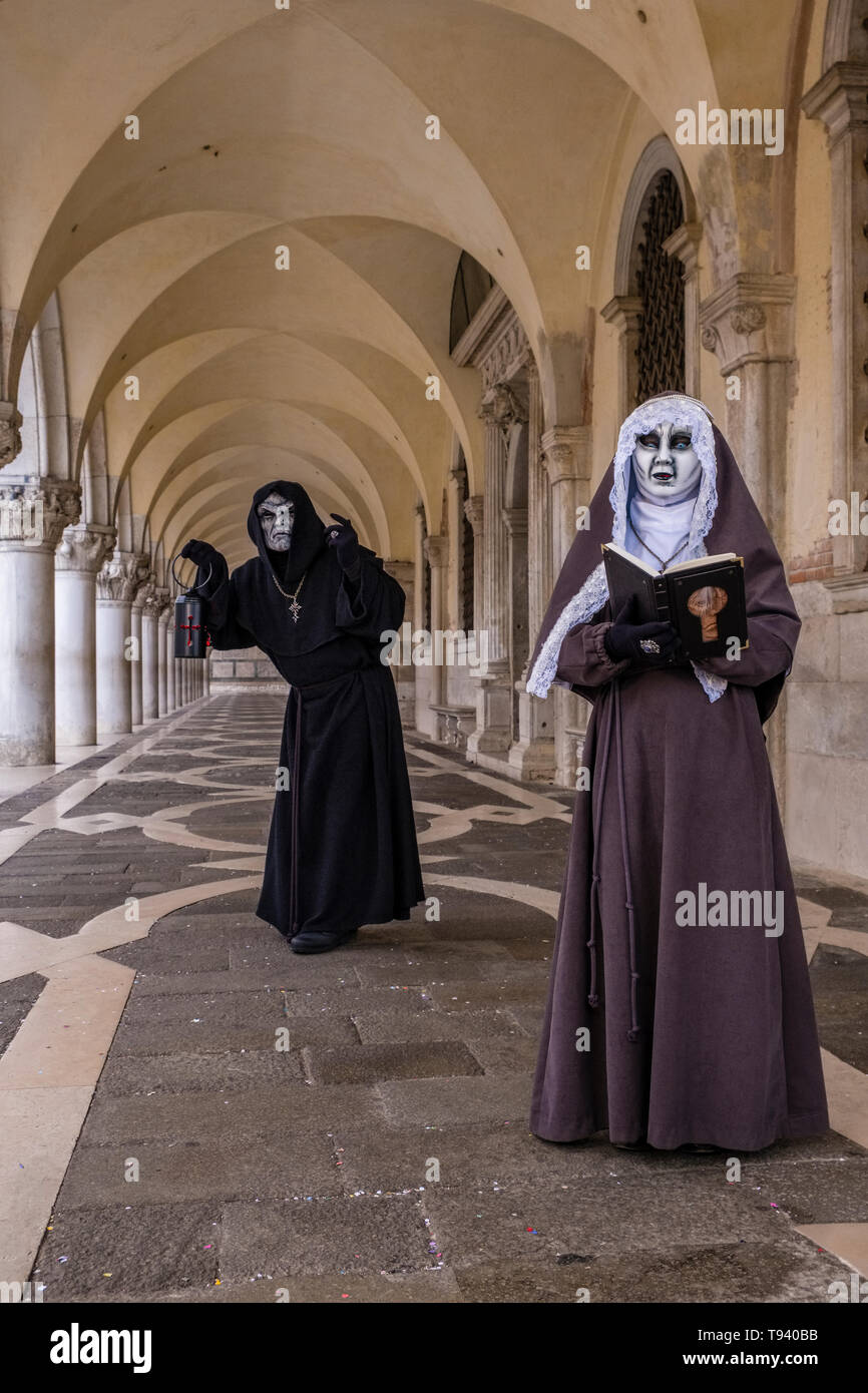 Una coppia mascherata in spaventoso costumi creative, ponendo sotto i portici di Palazzo Ducale, Palazzo Ducale, celebra il Carnevale Veneziano Foto Stock