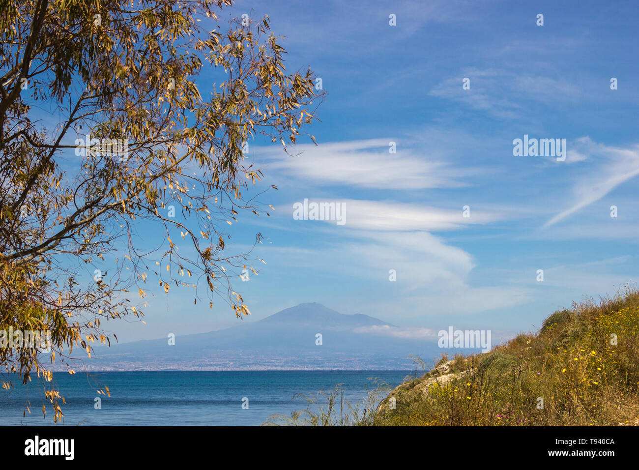 Brucoli vista del paesaggio marino in un telaio con un albero ed erba a parte e il blu del mare e del cielo con l'Etna in background Foto Stock