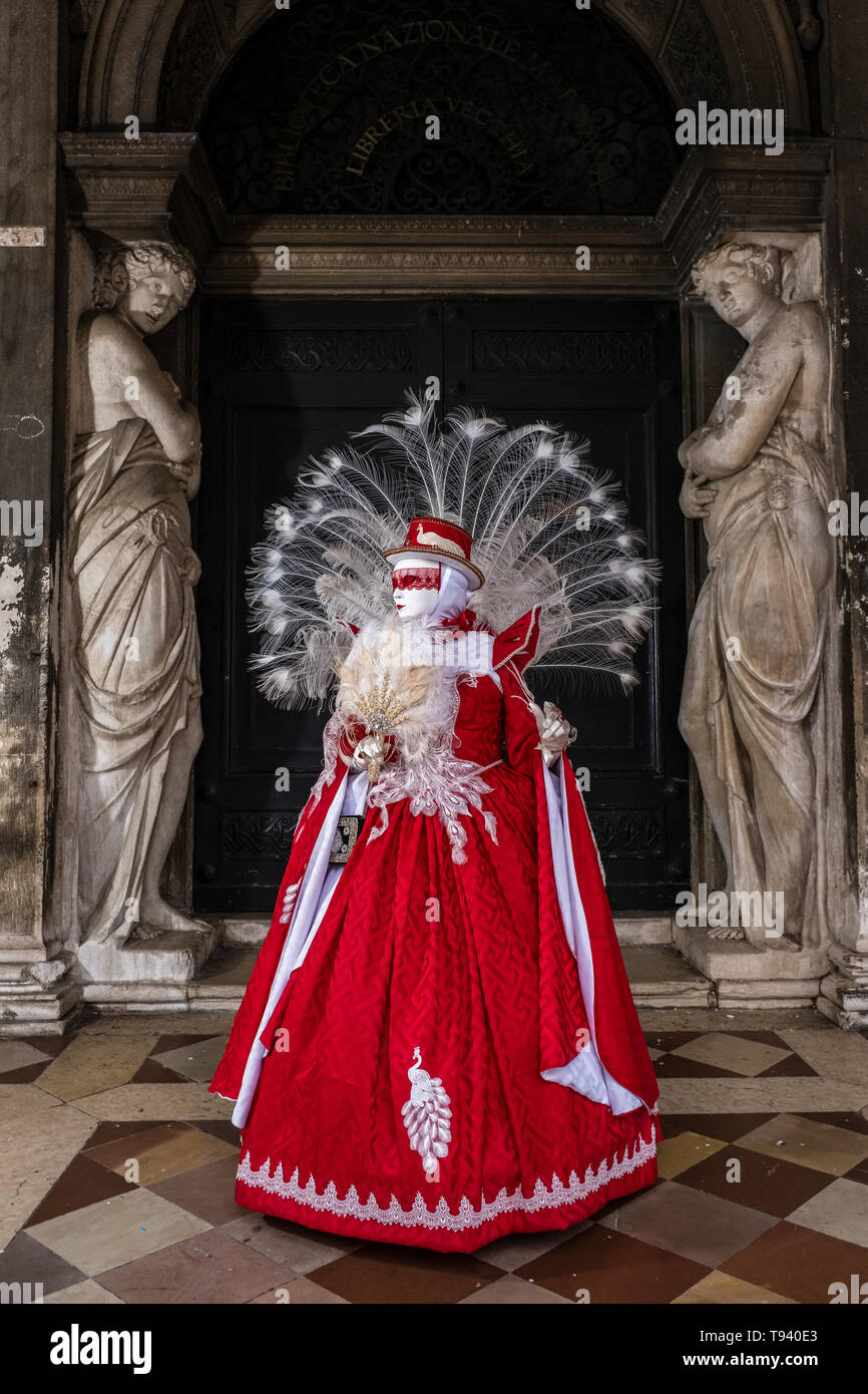 Un feminin persona mascherata in un bellissimo costume di creative, ponendo a portici di Piazza San Marco, Piazza San Marco, celebrando il veneziano Carniva Foto Stock