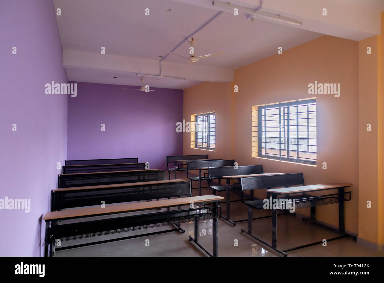 Classe vuota camera e scrivanie con pareti colorate Foto Stock